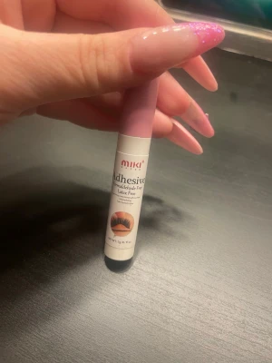 MIKI Adhesive lim för lösögonfransar - MIKI Adhesive är ett lim för lösögonfransar, formaldehydfritt och latexfritt. Tuben är vit med rosa lock och har en smidig, kompakt form som är lätt att ta med i sminkväskan. Perfekt för att fästa fransar snabbt och enkelt.