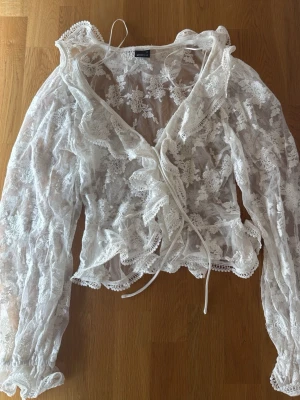 Vit spetsblus med volanger - Spetsblus perfekt till sommaren! Oanvänd utan prislapp. Aldrig använd bara provad. Pris kan diskuteras💕