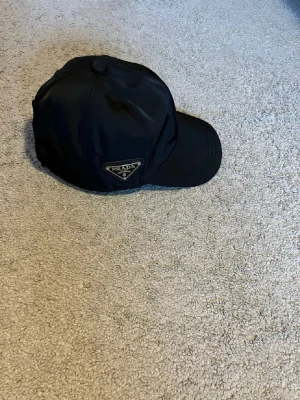 Unik keps - Säljer en keps från pr@da i storlek L men det går o justera på baksidan. Kepsen är inte autentisk men en bra k0pia. Pris går att diskutera