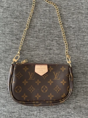 Fin väska med guldkedja brun - Jätte fin knappt använd väska med guldkedja och mönster