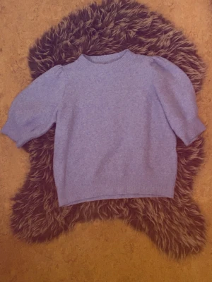 Ljusblå stickad tröja med puffärm - Supersöt ljusblå stickad tröja med puffärmar och rund hals. Tröjan har en rak passform och ribbade muddar vid ärmslut och nederkant.