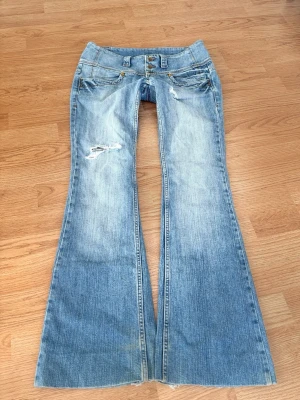 Vintage superlågmidjade bootcut jeans med slitningar - Såå sjukt snygga vintage superlågmidjade bootcut jeans med slitna detaljer!! ❤️❤️ Innebenslängd: 80 cm Midjemått rakt över: 39 cm