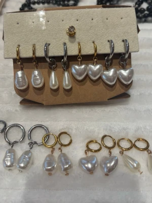 Örhängen med pärlor och hjärtan🌸🌸 - Säljer flera par örhängen med vita pärlor i olika former, bland annat droppar och hjärtan. Örhängena har både guldfärgade och silverfärgade ringar i rostfritt stål. Perfekta för dig som gillar unika accessoarer med pärldetaljer💍60kr för ett par