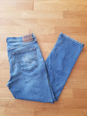 Levi's 567 - Säljer ett par klassiska blå Levi's Signature 567 jeans med rak passform. Jeansen har en bakficka med dekorativ söm och en läderpatch i midjan. Tillverkade i slitstark denim som ger en tidlös look. Perfekta för dig som gillar enkel och avslappnad stil.