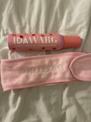 Ida Warg brun utan sol mousse + rosa hårband - Säljer en limited edition Berries & Cream Self-Tanning Mousse från Ida Warg i rosa flaska med röda detaljer. Medföljer ett mjukt rosa hårband med texten 'DAZZLING', perfekt för hudvårdsrutinen eller när du applicerar brun utan sol.