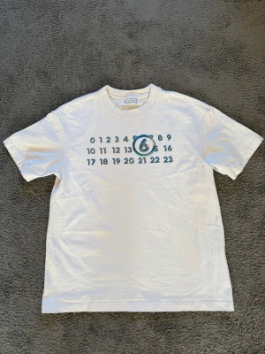 maison margiela T-shirt - Säljer en sjukt snygg maison margiela T-shirt med ett nice tryck, perfekt till våren och sommaren Den är knappt använd och i ett mycket fint skick.  MADE IN ITALY🇮🇹 Frågor? Kontakta mig✅ Allt gott, mvh Noah