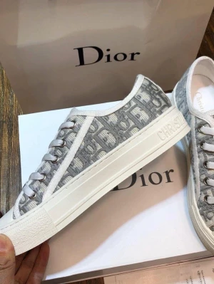 Dior Oblique låga sneakers - Snygga låga sneakers från Dior med ikoniskt grått och vitt oblique-mönster. Skorna har vita snören, metallöglor och en vit gummisula med svart stjärndetalj undertill. Perfekt för dig som vill ha en exklusiv och trendig look.