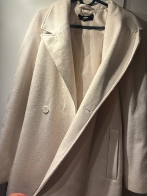 Vit kappa från Bik Bok med bälte - Vit/ljus beige kappa från Bikbok