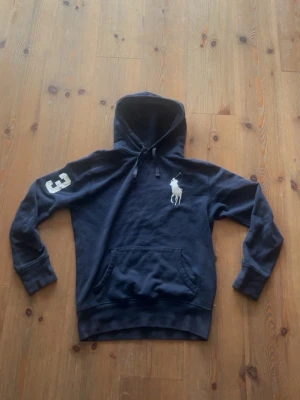 Marinblå hoodie från Polo Ralph Lauren - Säljer min feta Raffe hoodie då den börjar bli för liten passar 165-180. Skriv ba om ni har några frågor mvh Gustav 