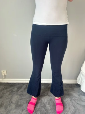 Mörkblå bootcut leggings - Säljer ett par mörkblå leggings med bootcut-ben. liten fläck på rumpan men går bort i tvätten! Inte yoga pants material!