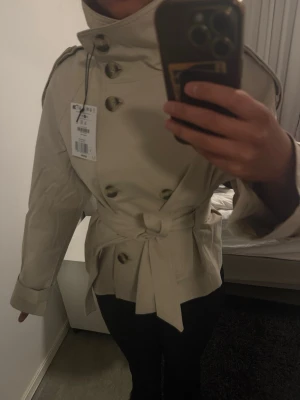 Beige trenchcoat med knytskärp - Trendig trenchcoat från bershka i storlek S, prislappen är fortfarande på.😊