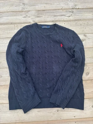 Ralph Lauren stickad tröja - Säljer en kabelstickad tröja från Ralph lauren i storlek M! Den har en liten defekt vid halskragen men inget allvarligt! Kom gärna med frågor och budförslag