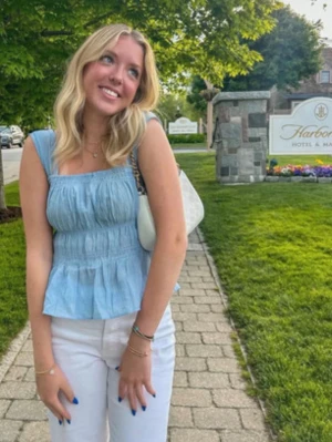 Ljusblå smockad linnetopp - Supersöt ljusblå linnetopp med smockad överdel och volang nedtill. Toppen är ärmlös med breda axelband och har en luftig, somrig känsla. Perfekt att matcha med jeans eller kjol för en fräsch look.