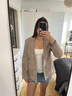 Beige kavaj i mocka - Stilren beige kavaj i mocka med två framfickor. Perfekt nu inför våren🤩