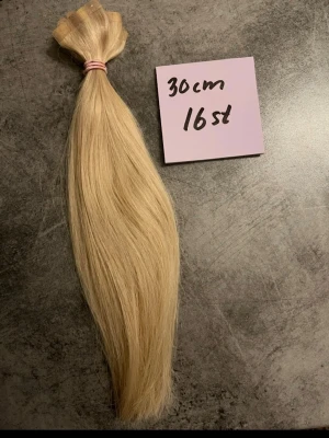 Slingat Blont löshår de är äkta hår - Säljer ett set med slingat blont löshår, ca 30 cm långt. Håret är rakt jag har tvättat och fixat de och klippt topparna på de man kan använda värme på de utan att de förstörs för de är äkta människohår inte plast, de är tejp löshår