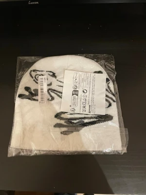 Vit mössa med svart grodmotiv - En snygg mössa som är jätte mjuk och passar perfekt för våren