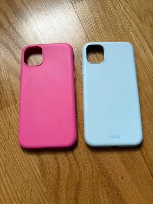 Färgglad skalduo  - Säljer två skal till IPhone 11 Apple. Ena är ett ljublått från Holdit och det andra ett rosa. Superfina men har inte den mobilen längre så hoppas de får en användning!! Pris är förhandlingsbart!