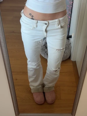 Vita jeans med raka ben - Säljer ett par vita jeans med raka ben och slitningar på låret och knät. Om man har större storlek funkar dom ändå eftersom dom sitter lite baggy men om man vill ha dom baggy så rekommenderar jag verkligen dom💞 Jeansen har några enstaka fläckar men dom knappast syns eller som man tänker på 