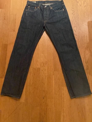 Mörkblå Levis 501 jeans  - Säljer ett par klassiska mörkblå jeans från Levi's i modellen 501. Jeansen är nästan helt nya och knappast använda. W31 och L30. Men skulle säga L31 också!