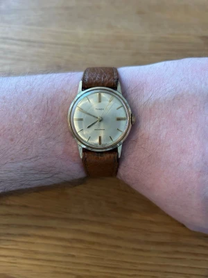 1968 Timex Mercury Mekanisk 32mm Herr - Säljer en mycket ovanlig brittisk Timex vintage-herrklocka från 1968 i nära nyskick enligt bilder. Mekaniskt V-Conic escapement urverk som fungerar bra, läderarmband lite slitet, vattentät, rostfritt stål case, stöttålig, osv. Behöver bara nytt batteri.  Begagnat pris: < 1200 SEK Mitt pris: 689 SEK  Skickas alltid snabbt och spårbart (ofta samma dag) eller hämtas i Glumslöv.  Hör av dig vid frågor och se gärna mina andra annonser också!   Year: 1968 Reference: 1048-2468 Model: Timex Mercury Move