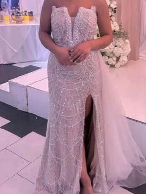 Champagnefärgad långklänning med pärlor - Elegant långklänning i champagnefärg med glittriga pärldetaljer och djup slits framtill. Klänningen har en unik v-ringad överdel med spetsig kant och är axelbandslös. Tyllsläp baktill ger extra volym och glamourös känsla. Priset går att diskutera vid snabb affär 🥰🥰