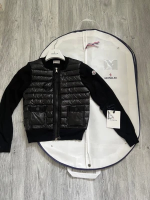 Moncler cardigan dam  - Hej! Jag säljer nu min jättefina Moncler cardigan. Cardiganen är i jättebra skick och har inga defekter eller liknande skicket 9,5/10. Den är äkta och köpt online. Jag säljer den pågrund av att den inte riktigt passar min personliga stil. Moncler dustbag lapprna osv ingår med jackan. Hör av dig vid minsta lilla fråga! 💕