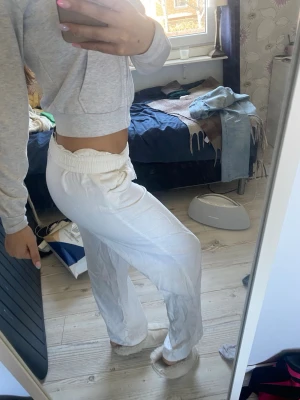 Vita loungebyxor med dragsko - Säljer ett par vita loungebyxor med resår i midjan och dragsko för skön passform. Byxorna har raka ben och är tillverkade i ett mjukt, tunt material som passar perfekt för chill dagar hemma. Superbekväma och enkla att matcha med en hoodie eller t-shirt.