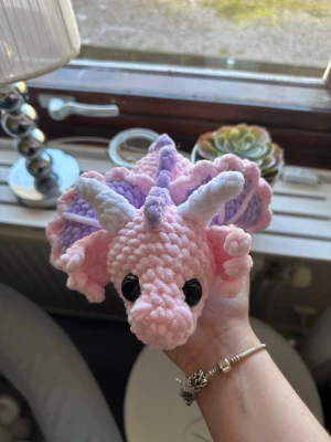 Virkad rosa och lila drake - Virkad ljusrosa drake med lila detaljer. Ca 27 cm lång. Den har säkerhetsögon som inte är lämpliga för barn under 3 år💗