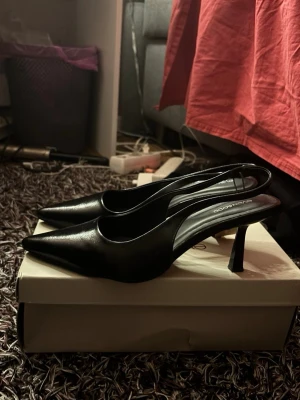 Svarta Klackskor - Säljer ett helt par nya klackskor i storlek 38 med öppen häl. 