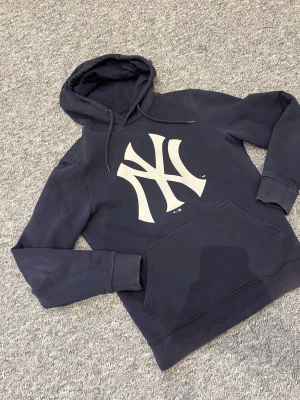Mörkblå New York Yankees hoodie - Snygg mörkblå hoodie från New Era. Den är i storlek S och sitter riktigt bra. Hör av dig vid minsta fråga 👍