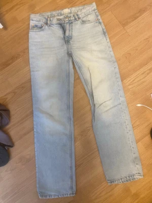 Ljusblå raka jeans - Säljer ett par ljusblå jeans med rak passform och klassisk femficksdesign. Jeansen har normal midja och är tillverkade i denim. Perfekta för en avslappnad och trendig stil.