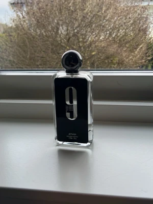 Afnan 9PM Eau de Parfum 100ml - Afnan 9PM Eau de Parfum i en stilren, rektangulär glasflaska med svart etikett och silverdetaljer. Doften är känd för sina varma, kryddiga och söta toner. Perfekt för dig som gillar unika och moderna parfymer. Jag vill gärna bli av med de