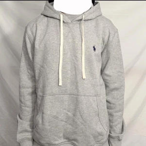 Ralph Lauren hoodie - Snygg grå hoodie från Ralph Lauren i bra skick. Klassisk modell med broderad logga på bröstet och skön passform. Vid frågor eller funderingar tveka inte att höra av dig pris går att diskuteras