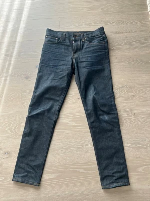 Nudie Jeans Steady Eddie 2 Dry Heavy - Säljer ett par fräscha selvedge jeans från Nudie i modellen Steady Eddie 2, med slitningen Dry Heavy. De är i storlek 33 midja 34 längd. Pga av att de knappt är använda så har de ännu inte tvättats ännu och kan därför fortfarande anpassas till bäraren. Bara att höra av sig funderingar!:)