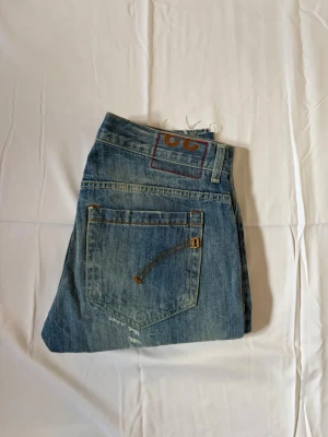 Dondup jeans - Säljer ett par blå dondup jeans med slitningar det som sticker ut med dessa jeans är att slitningarna är original alltså gjord av dondup. Dem är väldigt eftertraktade. Modellen är 179 cm lång