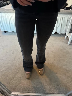Svarta bootcut jeans från Gina Tricot - Säljer ett par utvättat svarta bootcut jeans från Gina Tricot. Jeansen har en snygg tvätt, klassiska fickor och utsvängd passform nedtill. Perfekta till sneakers eller boots och riktigt sköna att bära hela dagen.