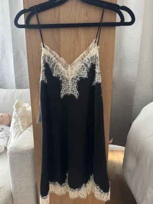 Svart nattlinne med spets från Zara - Slutsåld som inte säljs längre! Svart linnetopp från Zara med tunna axelband och v-ringad hals. Perfekt att styla lager på lager eller som statement-piece.