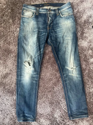 Nudie thin finn - Säljer nu dessa nudie jeans med en riktigt schysst tvätt och snygga slitningar. Modell: Thin Finn. Längd: 102cm. Bredd: 45cm. Bara att höra av sig med frågor och funderingar!