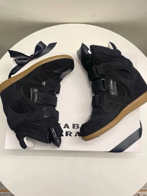 Isabel Marant svarta high top sneakers - Säljer mina isabell marrant, dom ska vara helt nya och äkta. Säljer dom då dom var för stora för mig. Dustboxen kommer tyvärr inte med då jag vill spara den men pris går att diskutera vid snabb affär och det är bara att höra av sig vid funderingar eller fler bilder! ❣️❣️