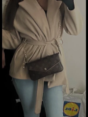 Beige kappa med knytskärp - Stilren beige kappa med bred krage och knytskärp i midjan. Från missäy i storlek S kommer inte till användning ❤️