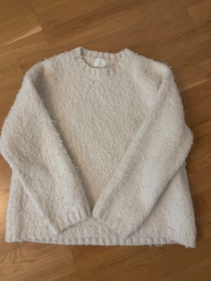 fluffig stickad tröja - så fin ljus beige/vit stickad tröja ifrån h&m, den är skön och fluffig i materialet😇 inga defekter och endast använd fåtal gånger!!