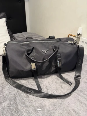 Prada adidas Re-Nylon Duffle Bag - ✅ Perfect condition  – Brand new, never worn  💯 100% Authentic products only 📦 Fast shipping ♻️ Shop sustainably, look sharp.  REMINDER: Items can be used and please note that we only resell used clothes we buy online (some are brand new).   We will always tell our customers before buying if item has stains or is damaged. Returning is always possible  Bought in here. If you have anything authentic to sell, let us know because we also buy and sell on here🙂  Thank you!.