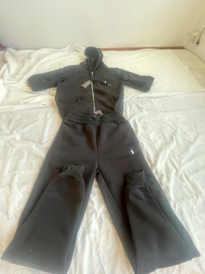 Svarta mjukisbyxor från Ralph Lauren - Svarta mjukisbyxor från Ralph Lauren med klassisk logga broderad på benet. Byxorna har resår i midjan och vida ben, samt mjukt och skönt material. Perfekta för en avslappnad och trendig stil.