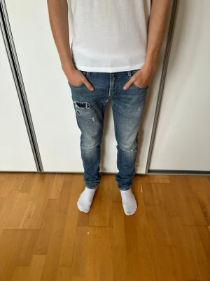 Blå slitna skinny jeans med hål - Säljer ett par unika replay anbass jeans, ruggit schyssta som passar alla outfits. Skriv vid funderingar. Priset ej hugget i sten