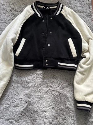 Svartvit cropped bomberjacka - Cropped bomberjacka från H&M! Använd ksk 5 gånger för flera år sen. ( Xs-xxs) 