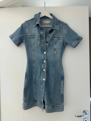 Jeansklänning med knappar från Zara - Snygg kort jeansklänning från Zara. Använd endast några enstaka gånger. Storlek S