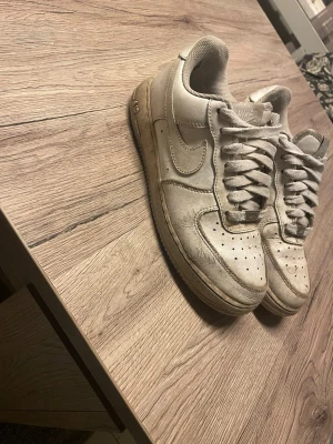 Vita Nike Air Force 1 sneakers - Klassiska vita Nike Air Force 1. Lite slitna då de har använts ett tag men inte så extremt slitna går att fräscha upp dom lite. Några små hål på undersidan. Kom me prisförslag. 