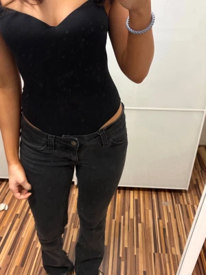 Svarta jeans med låg midja - Snygga svarta jeans med låg midja och klassisk femficksdesign. Tight passform och stretchigt material som sitter bekvämt. Perfekta till en trendig och avslappnad stil. Klippta längst ner för att passa längden