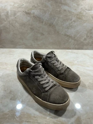 Grå vagabond S 40 - Stilrena sneakers i grå mocka med matchande grå skosnören och beige sula. Klassisk låg modell som passar till det mesta. Ovandelen är i mjukt mockamaterial och sulan är i gummi för bra komfort. Perfekta för en avslappnad och trendig look. Skick 8/10