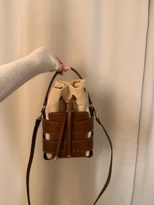 H&M bucket bag - Säljer den eftertraktade bucket bag från h&m. Den är helt slutsåld. Säljer då jag inte använt på ett tag. Väskan har några smink fläckar inuti men går bort med mielervatten. 